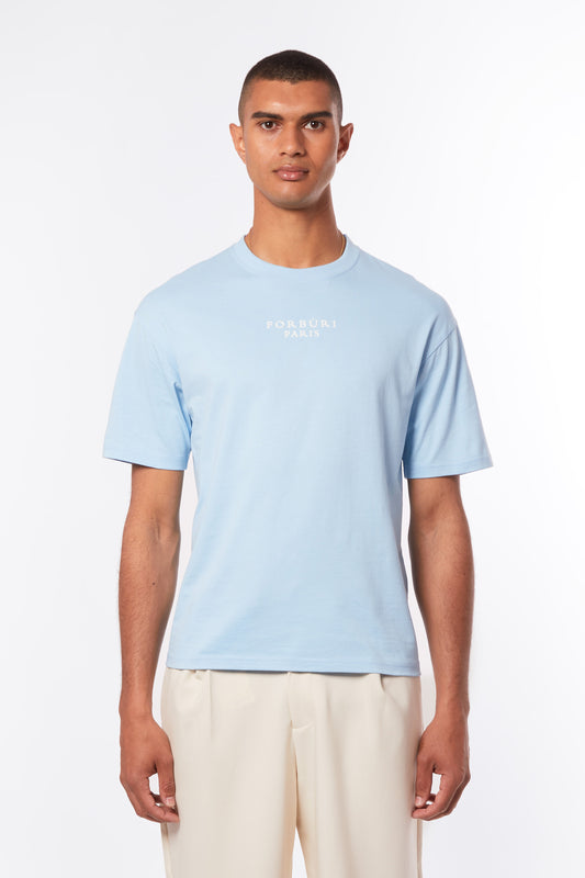 Lagoon blue men’s T-shirt by Forburi Paris. Premium cotton with a minimalist design for a fresh, timeless summer look inspired by European coastal style. Lagoon blue men’s T-shirt – Forburi premium cotton summer essential with minimalist logo – perfect for urban men’s fashion with fresh coastal vibes (t-shirt homme bleu lagon, style été, vibes balnéaires).

