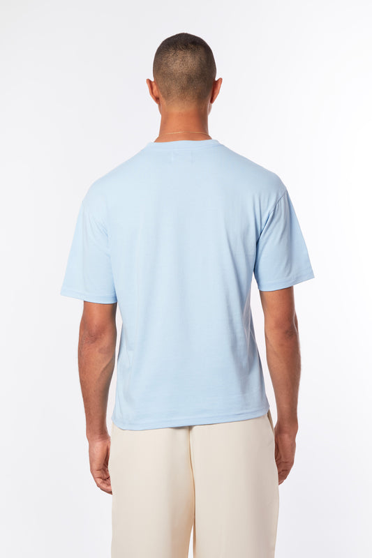 Lagoon blue men’s T-shirt by Forburi Paris. Premium cotton with a minimalist design for a fresh, timeless summer look inspired by European coastal style. Lagoon blue men’s T-shirt – Forburi premium cotton summer essential with minimalist logo – perfect for urban men’s fashion with fresh coastal vibes (t-shirt homme bleu lagon, style été, vibes balnéaires).

